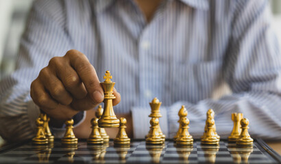 Businessman moving gold Chess King figure and Checkmate opponent during chessboard competition....
