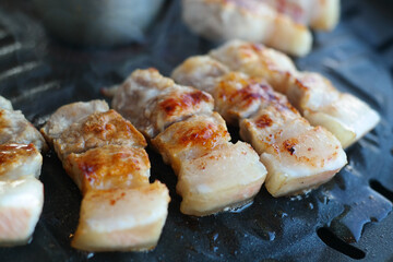 Close-up of pork being cooked on an iron plate