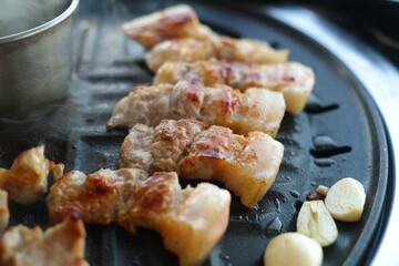 Close-up of pork being cooked on an iron plate