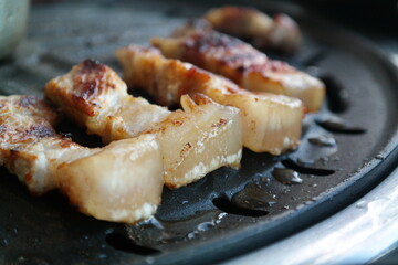 Close-up of pork being cooked on an iron plate