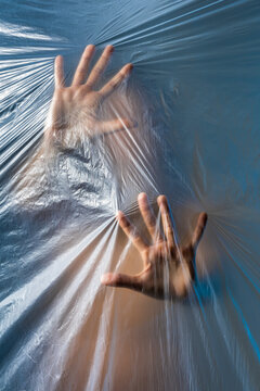 Woman touching plastic film while standing behind it
