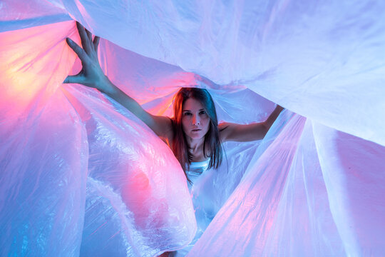 Woman looking at camera through plastic film
