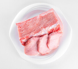 Raw meat on white plate on white background