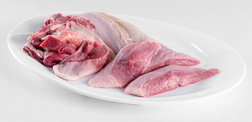 Fresh pork offal on a white plate on a white background