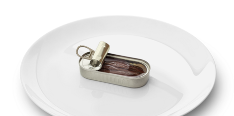 Opened tin can of anchovy fillet in oil on a white plate solated on a transparent background