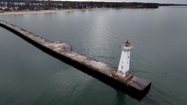 Historic Lighthouse at Sodus Bay New York by Lake Ontario during Winter under grey skies