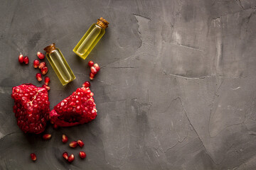 Pomegranate seed oil in glass bottle with pomegranate fruit. Natural cosmetic and treatment