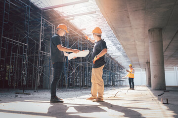 Concept of construction. Engineer, architect and designer working together at the construction site, Foreman or engineer checking the accuracy of the construction work by using blueprints..