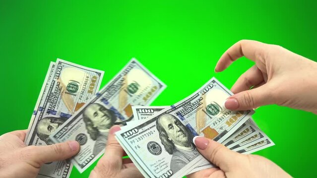 on green background chromakey male hands give one hundred dollar bills to female hands woman counts each banknote considering its authenticity at end they show thumbs up happy with deal resolution buy