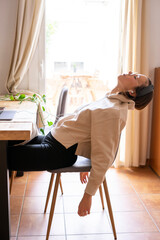 girl working at home. Girl leaning on the chair and letting her arms drop from exhaustion	