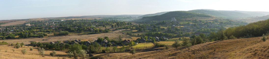 Fototapeta na wymiar Beautiful rural landscape of a settlement on the hills, steppe rural life. Panorama.