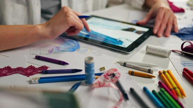 Design studio for creative people. Fashion designer, draws on a tablet Fashionable clothes. Closeup Girl Actively Working Workspace, Creator Creates
