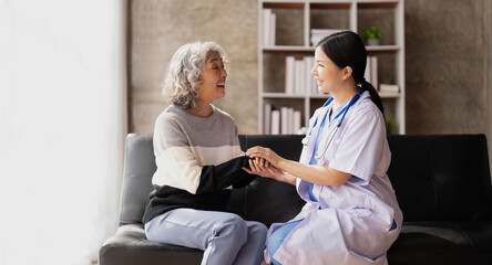 Home caregiver and senior woman holding hands. Professional Elderly Care. Professional care for elderly at nursing homes. Nurse holding hand of senior woman in rest home