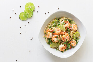 Shrimp pasta lemon coriander in white bowl on white background Italian food.