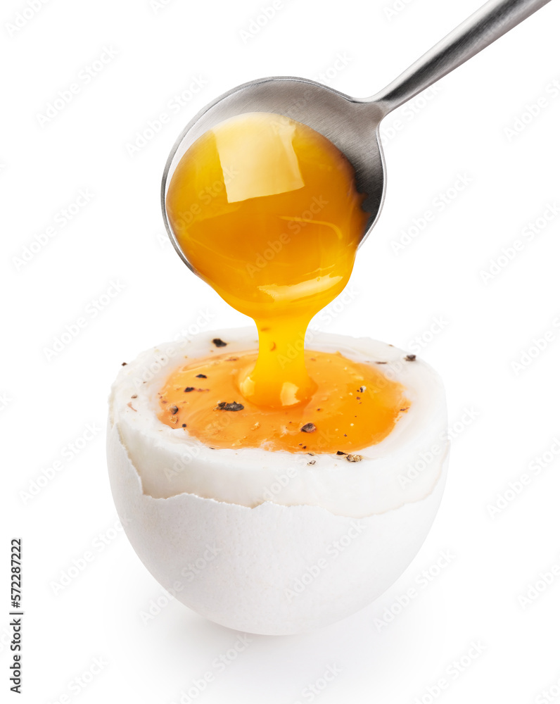 Wall mural spoon takes the yolk of the soft-boiled egg isolated on white background. with clipping path.