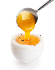 Spoon takes the yolk of the soft-boiled egg isolated on white background. With clipping path.