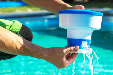Pool Chemical Dispenser in Hands of Technician