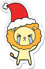 sticker cartoon of a crying lion wearing santa hat