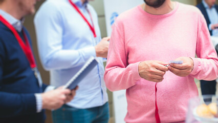 Process of checking in on a conference congress forum event, registration desk table, visitors and attendees receiving a name badge and entrance wristband bracelet and register electronic ticket