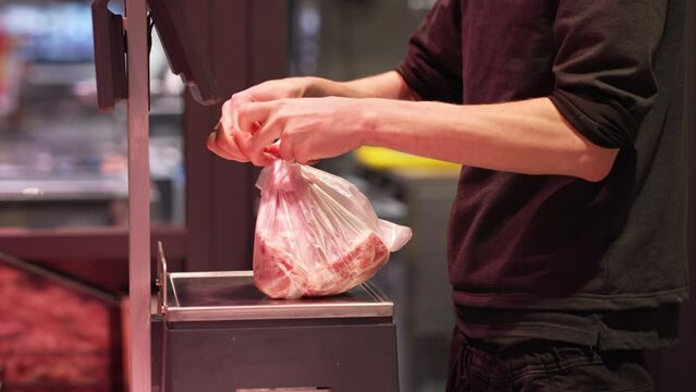 The seller weighs and packs the meat for the buyer