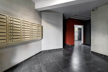 interior entrance to an apartment building with mailboxes with grey walls.