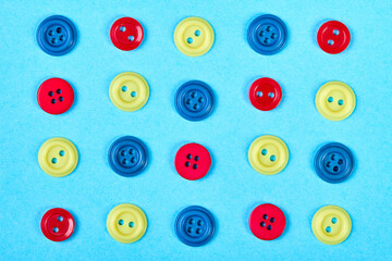 A set of multicolored buttons for clothess on a blue background