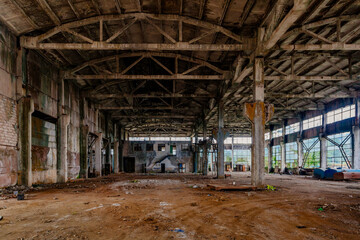 Fototapeta na wymiar Abandoned factory. Large empty industrial hall waiting for demolition
