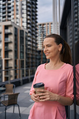 Manager, a woman in a pink dress stands on terrace