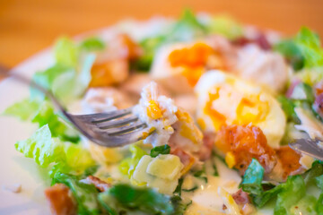ポーチドエッグのチキンサラダを食べる