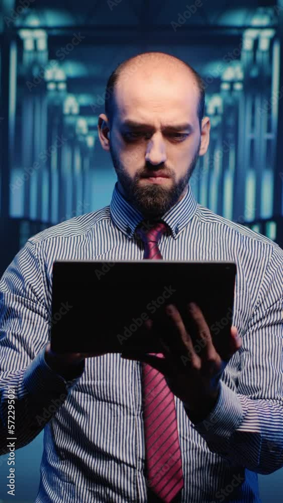Poster vertical video: male infrastructure specialist using tablet for hardware digitalization, inspecting 