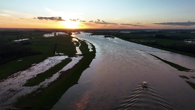 Ship sailing on the river IJssel in Overijssel aerial view during a winter sunset.