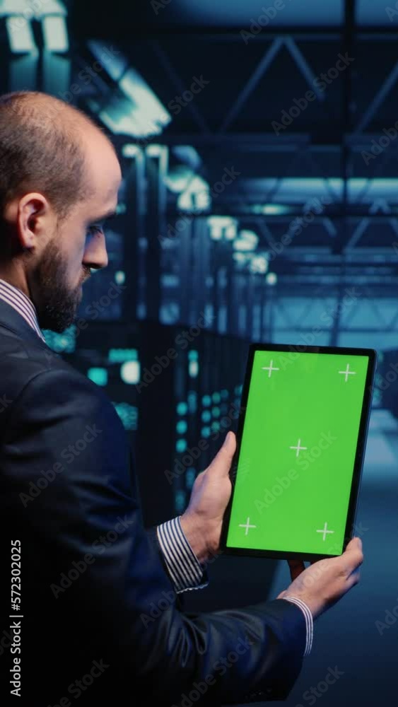 Poster vertical video: database admin analyzing greenscreen display on tablet, doing web system check in se
