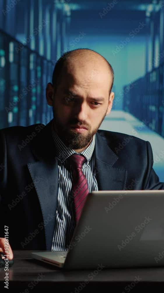 Poster vertical video: data center technician feeling tired working in server room, doing cloud computing d