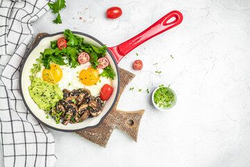 Breakfast skillet pan of fried egg, avocado and mushrooms. Ketogenic diet. Low carb high fat breakfast. Healthy food concept. place for text, top view