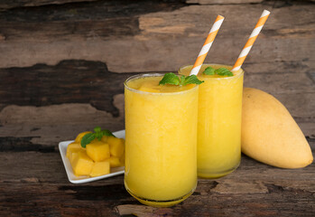 Mango smoothies orange colorful fruit juice beverage healthy high protein the taste yummy in glass on wood background from top view.
