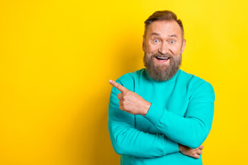 Photo portrait of handsome granddad point excited empty space unbelievanle dressed stylish cyan outfit isolated on yellow color background