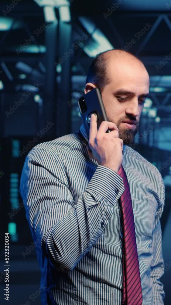 Aufkleber vertical video: information security officer talking on phone call, working in professional data cen
