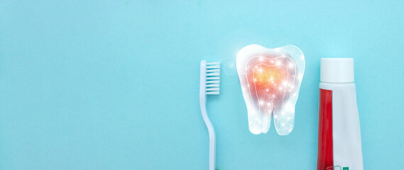 Close up of a toothbrush and toothpaste with thin linear Low poly tooth icon on blurred blue background. Oral Care Concept. Concept of oral hygiene in the family.