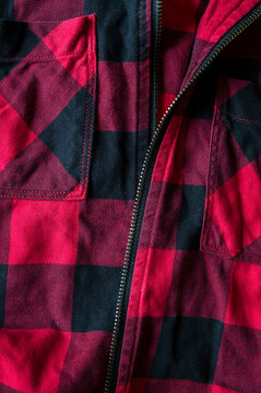 Closeup view of a red abd black check shirt. 