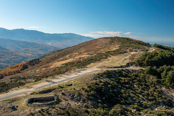 Fototapeta premium Aerial view Drone landscape autumnal mountainous with sun with resting area and shelter for animals, trees, plants and rocks in the north of Extremadura, Spain.