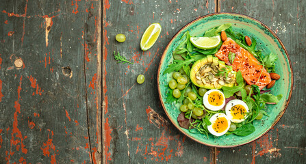Keto bowl salmon salad with greens, eggs and avocado. Ketogenic diet breakfast lunch. Long banner format. top view