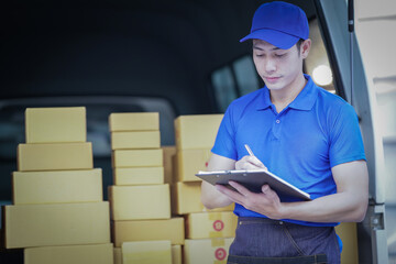 Deliver service. Man With Box in Car Outdoors Delivery Man in uniform holds parcel and phone car outdoors Delivery man taking parcels from The Delivery service.