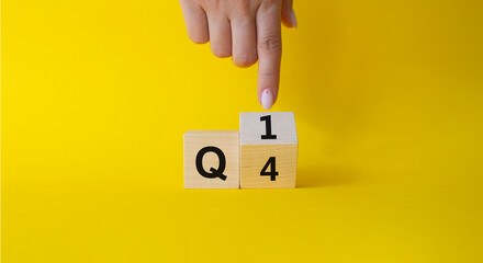 From 4th Quarter to 1st symbol. Businessman hand points at Turned wooden cube with words 4th...
