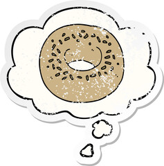 cartoon donut and thought bubble as a distressed worn sticker