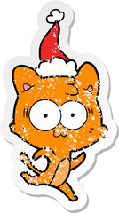 distressed sticker cartoon of a surprised cat running wearing santa hat