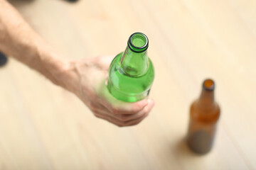 a person holds a green bottle in his hand
