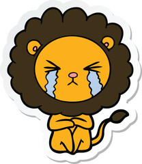 sticker of a cartoon crying lion sitting huddled up