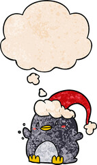cartoon penguin wearing christmas hat and thought bubble in grunge texture pattern style