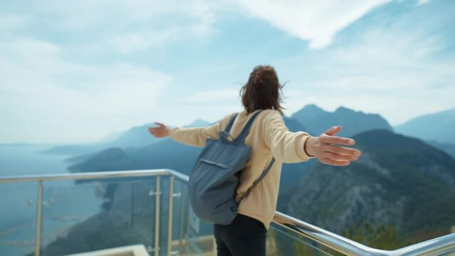 side view traveler freedom woman with open arms laughing and enjoying mountains view, summer journey vacation
