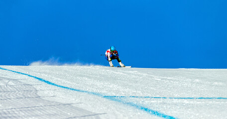 man mountain skier on track of giant slalom in background blue sky